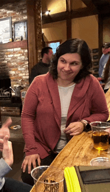 a woman sits at a bar with a cup that says buck 's