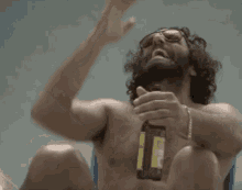 a shirtless man with a beard is drinking from a bottle of beer