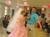 a man in a blue shirt is dancing with a girl in a pink dress in front of a sign that says france