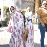 a woman in a pink and white polka dot dress with tassels