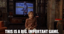 a young boy is sitting on a bouncy chair in front of a television with the words `` this is a big important game '' .