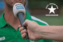 a man in a green shirt is being interviewed by a person holding a microphone that says moonen movies