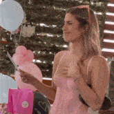 a woman in a pink lace top is holding a piece of paper with a heart sticker on it