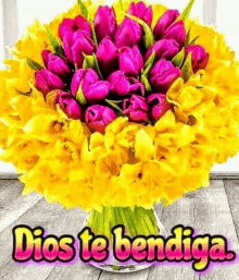 a bouquet of pink and yellow flowers in a vase with the words `` dios te bendiga '' written on it .