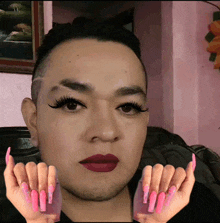 a man with long pink nails and red lips