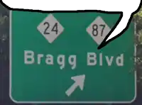 a green sign that says bragg blvd with an arrow pointing right