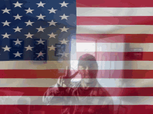 a man giving the middle finger in front of a large american flag