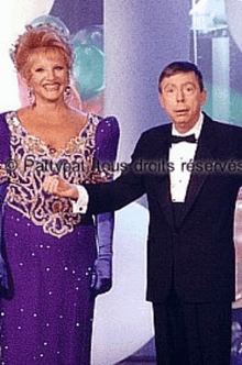 a man in a tuxedo and a woman in a purple dress are standing next to each other