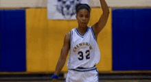 a female basketball player in a white jersey with the number 32 on it is standing on a court .