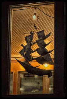 a model of a ship is hanging from the ceiling of a building