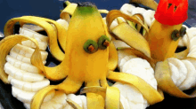 two bananas with faces carved into them are surrounded by banana slices