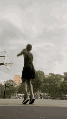 a person is playing basketball on a court with a basketball hoop in the background