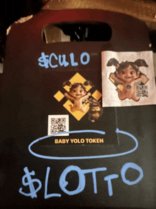 a baby yolo token sticker is on a black board