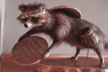 a stuffed raccoon wearing a headband and a hat holds a basket