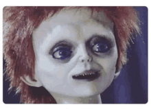 a close up of a creepy doll 's face with red hair .