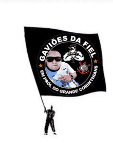 a man is holding a black flag that says gavioes da fiel on it