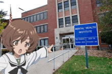 a girl stands in front of a building with a sign that says mental health institute