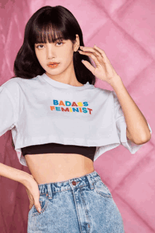 a woman wearing a crop top that says badass feminist on it