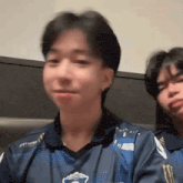 a man in a blue shirt is making a funny face next to another man .