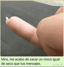 a close up of a person 's thumb with a message in spanish