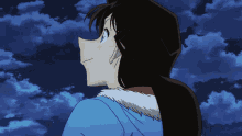 a girl in a blue coat looks up at the sky