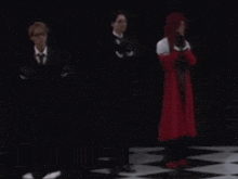 a group of people are standing on a checkered floor .