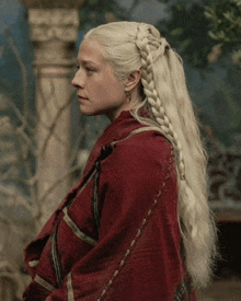 a woman with blonde hair is wearing a red coat and a braided ponytail