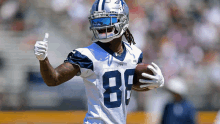 a football player wearing a cowboys uniform giving a thumbs up