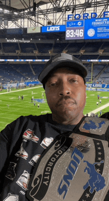 a man holding a lions championship belt in front of a stadium