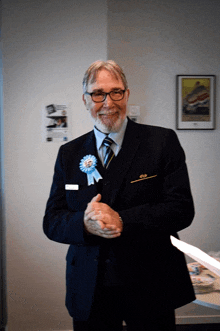 a man in a suit and tie has a blue ribbon on his jacket