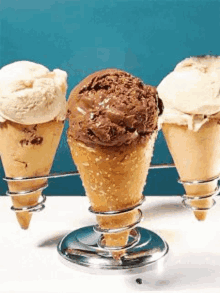 three ice cream cones with different flavors on a table