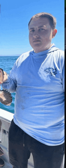 a man in a blue shirt is holding a fish