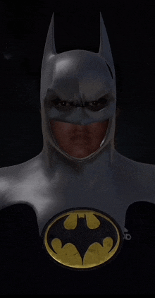 a man in a batman costume with a yellow bat on his chest