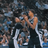 two basketball players one of whom has the number 1 on his shirt