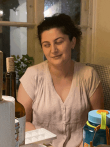 a woman sitting at a table with a bottle of wine and a nalgene bottle