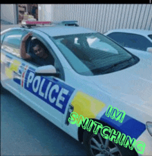 a man is sitting in a police car that says police snitching on the side