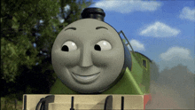 a cartoon train is smiling and looking at the camera with trees in the background