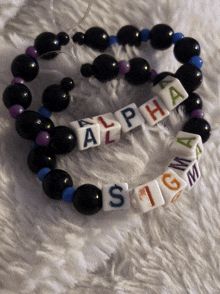 a pair of bracelets that say alpha and sigma