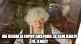 an elderly woman is sitting in front of a window with the words `` ma nisam ja lopov gospodaro ja sam jebac ! ''