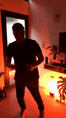 a man in a black shirt is standing in a room with red lights