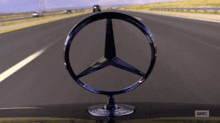 a close up of a mercedes logo on a car with a blurred background
