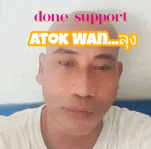 a man with a shaved head has done support atok wan written above his head