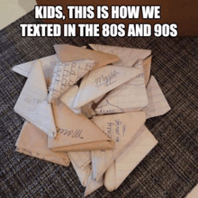 a pile of envelopes with the words " kids this is how we texted in the 80s and 90s "