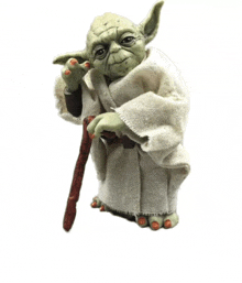 a statue of yoda is holding a cane and wearing a robe