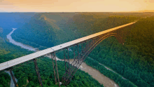 a bridge over a river surrounded by trees and cliffs