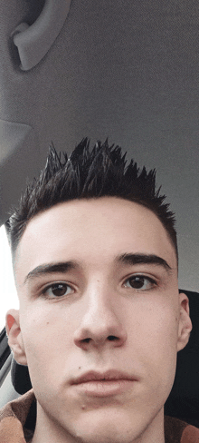 a close up of a young man 's face with a very spiky haircut