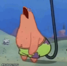 patrick star from spongebob squarepants is hanging upside down from a rope .
