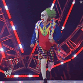 a man in a clown costume is walking on a stage