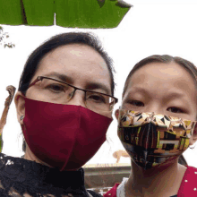 a woman wearing a red mask and a girl wearing a yellow mask with the word aya on it