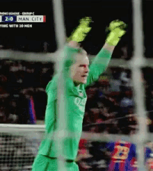 a soccer player in a green jersey is raising his arms in the air during a game between man city and fc barcelona